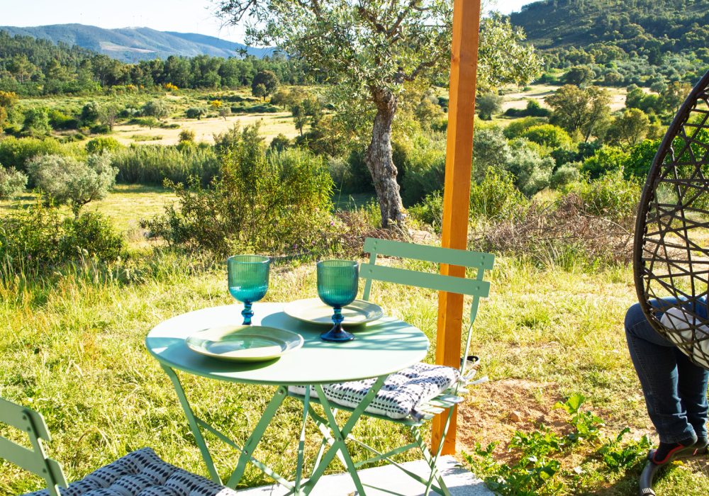 Terraço do apartamento T0 com mesa e cadeiras ao ar livre, vista para o campo em Terras do Salvado